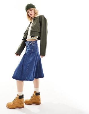 ASOS DESIGN denim pleated knee length skirt in midwash blue offers at $49.99 in Asos