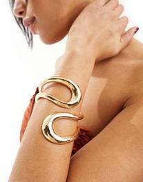 ASOS DESIGN cuff bracelet with wrap around open design in gold tone offers at $21.99 in Asos